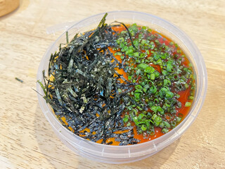 Chilled silken tofu drizzled with savory sauce, garnished with seaweed and chopped scallions.