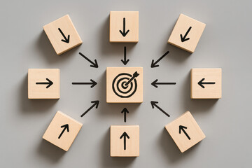 Concentration focus and strategy is symbolized by wooden blocks directing attention toward a central target icon representing business alignment and goal achievement
