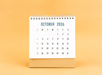 October 2026 desk calendar on yellow background, Front view.