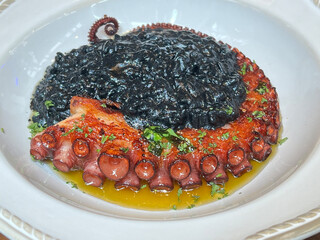 Squid ink risotto with grilled octopus tentacle.
