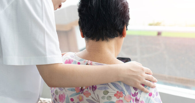 Elderly female hand holding hand of young caregiver at nursing home.Geriatric doctor or geriatrician concept. Doctor physician hand on happy elderly senior patient to comfort in hospital examination