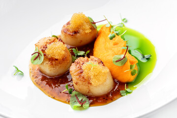 Fried scallops with fish caviar and sauce on plate isolated on white background. Seafood, close up, top view