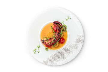 Grilled octopus with vegetables and sauce in plate isolated on white background. Healthy food, top view, close up © Julia's Graphicland