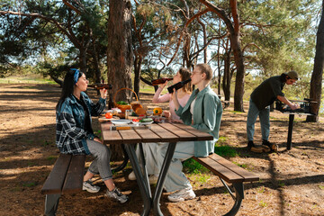 Obraz premium Friends Enjoying a Relaxing Picnic in the Forest