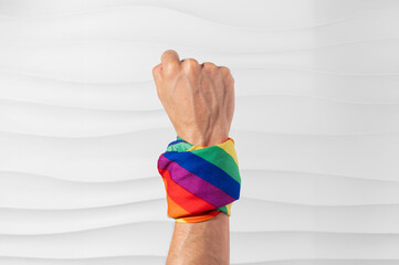 Brazo con puño en alto con bandera pride en el brazo en señal de lucha y esfuerzo por derechos igualitarios