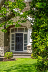 Entrance of grey painted luxury house in spring with stair steps and nice landscape in Vancouver, Canada, North America. Day time on May 2025.