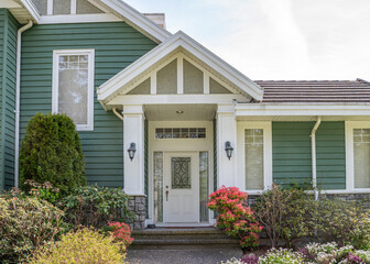 Entrance of grey painted luxury house in spring with stair steps and nice landscape in Vancouver, Canada, North America. Day time on May 2025.