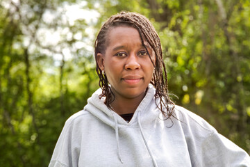 Confident African Woman in Gray Hoodie Outdoors in Sunlit Park