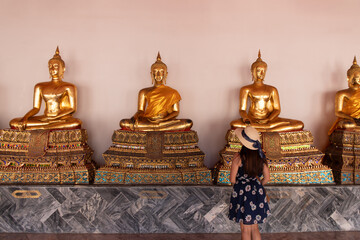 Tourists look at golden Buddha in Temple , Bangkok Thailand	