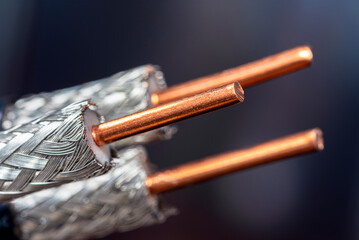 Coaxial cable with exposed shielding and central conductor, on a dark background, close-up view