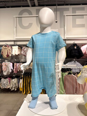 Mannequins child dressed in blue overalls in a fashion store