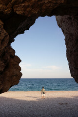 Explorer Stands at Cave Entrance