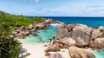 Pristine turquoise bay with white sand beach and surrounded by lush green vegetation. Seychelles, La Digue. Anse Cocos.