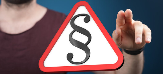 Stock photo of a hand interacting with a 3D warning sign featuring a paragraph symbol, signifying...