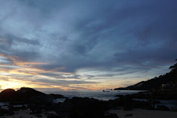 Obraz premium Serene Coastal Sunset with Gentle Waves and Rocky Shoreline at Dusk in Tranquil Setting