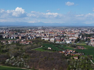 Naklejka premium Drone shot of Novara's countryside showing the city edge, surrounding farmland, and a local highway cutting through the landscape.