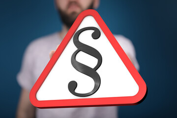 A person holds up a red triangle warning sign with a paragraph symbol.  Legal notice concept.