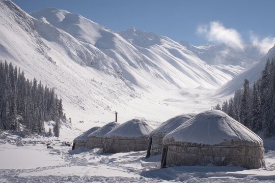 Winter yurt village nestled in a snowy valley surrounded by majestic mountains during bright daylight