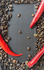 Bar of extra dark chocolate with three red chili peppers on a background of coffee beans. Trend food concept. Selective focus. Vertical orientation