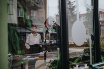 Two people engaged in a conversation inside a cozy co-working space, blending natural interiors with urban aesthetics and teamwork