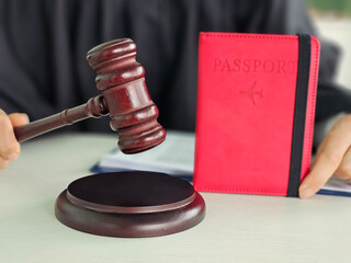 Judge gavel in front of a passport on a courtroom desk during a legal proceeding concept