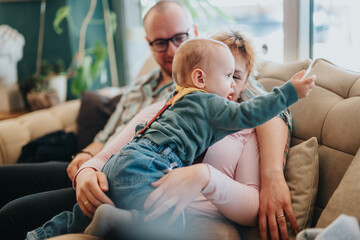 A family sharing precious moments at home, conveying love, care, and happiness in their interactions on a cozy living room couch.