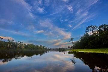 Fototapeta premium A breathtaking sunrise over the mirrored waters of Pacaya Samiria, where silence, mist, and color merge into one of nature’s most sacred rituals. Deep in the heart of the Peruvian rainforest.
