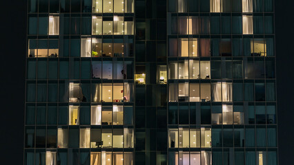 window of the multi-storey building of glass and steel lighting and people within timelapse