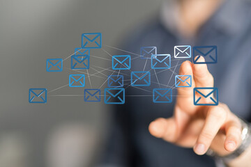 Hand interacting with a network of email icons.  Represents global communication and connectivity.