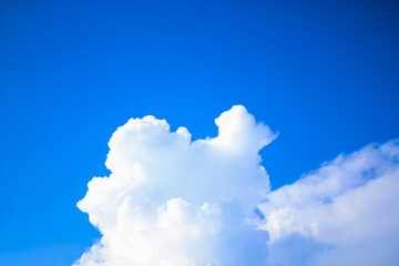 White clouds float quietly amidst a clear blue sky. This simple yet peaceful moment perfectly captures the serene beauty of nature, evoking both imagination and peace at the same time.