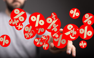Image depicts a man interacting with red percentage symbols, ideal for discount, sale, or finance...