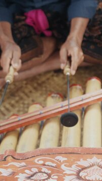 Musician playing traditional balinese gamelan instrument
