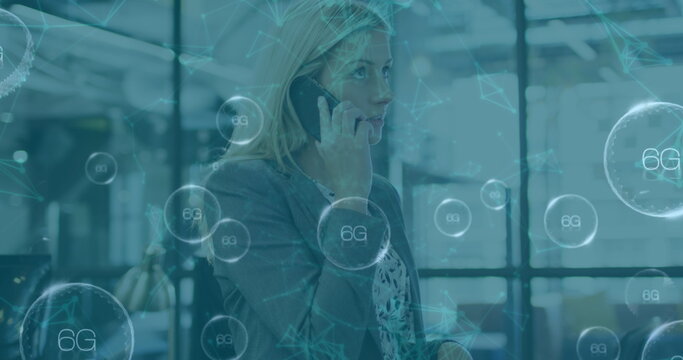 Image of data processing over caucasian businesswoman talking on smartphone in office