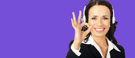 Portrait image of happy smile corporate customer support callcenter phone operator in headset show pointing okay ok hand sign gesture, isolate violet purple background with free ad slogan text space
