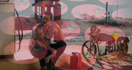 Image of barrels over caucasian man at petrol station