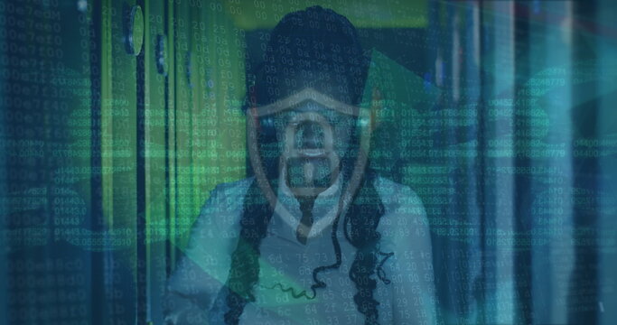 Image of data processing over african american female server room worker using headphones