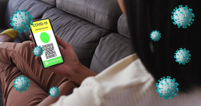 Image of covid 19 cells over woman relaxing at home with digital covid passport on phone screen