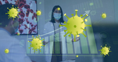 Image of graph and virus cells over diverse doctors wearing face masks