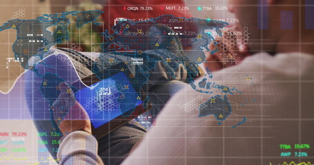 Holding tablet, analyst wearing light blue shirt, dark pants on lounge sofa, with digital world map