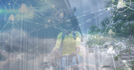 Image of network of connections over african american woman on bike and clouds