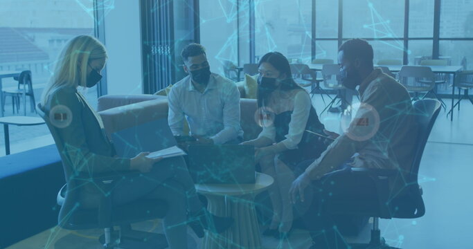 Image of data processing over diverse business people with face masks talking in office