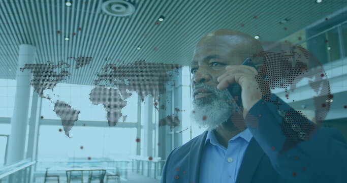 Image of world map over african american businessman with smartphone - Powered by Adobe