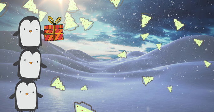 Fototapeta Balancing penguins stacking in snowy hills, with gift box, suitcase holding tree shapes, copy space