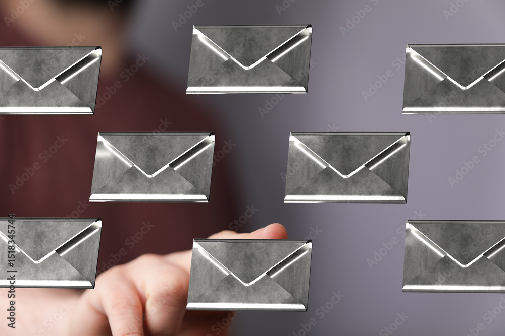 Aufkleber close-up of a hand selecting a digital email from a group of metallic envelopes.