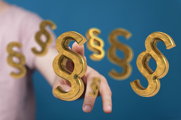 Abstract image of a hand reaching for golden paragraph symbols, ideal for legal or law concepts.