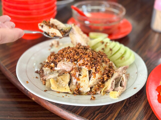 Pek Cam Kee, a traditional Hokkien-style poached chicken dish, served with fragrant garlic oil and accompanied by dipping sauces, captured in Puncak, Cipanas, West Java, Indonesia.

