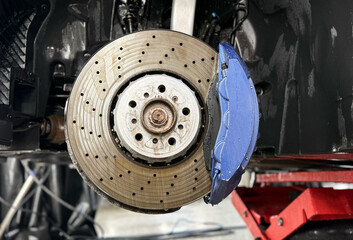 Car ventilated front brake disc with blue caliper. Modern perforated brake disc with ventilation...