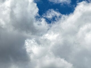 Obraz premium Blue sky with clouds background, sunny day. White and grey fluffy cloudscape