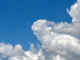 Obraz premium Blue sky with clouds background, sunny day. White and grey fluffy cloudscape