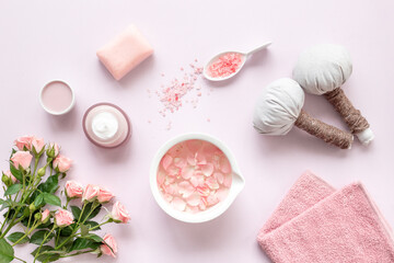 Beauty routine concept. Facial roses essence water and face cream with pink flowers and petals, top view